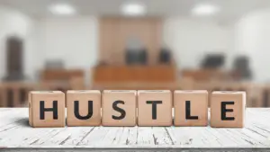 toy blocks on table spelling out HUSTLE